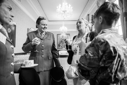 People speaking with glasses and tea cups in their hands