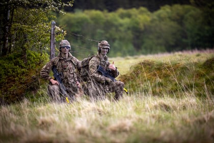 Two male cadets kneel on the ground during fieldcraft exercise at Cadet Cambrian Patrol 2026