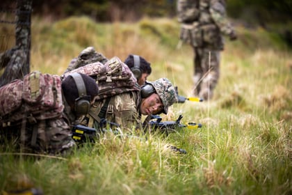 Cadets lie on the ground with weapons drawn during fieldcraft exercise at Cadet Cambrian Patrol 2026