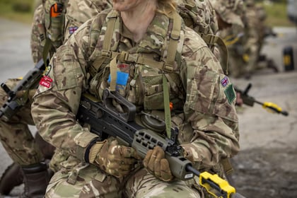 Female cadet kneels during fieldcraft exercise at Cadet Cambrian Patrol 2026