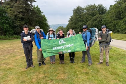 Cadets stand holding a green DofE flag
