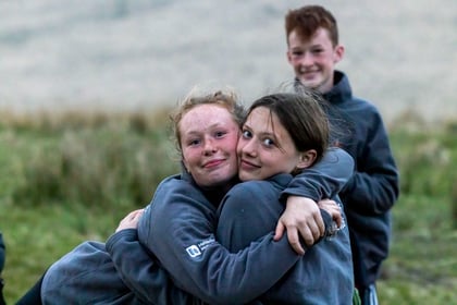Two female cadets give each other a hug