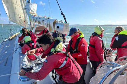 Army Cadets work together to steer a tall ship and operate the winches while sailing in challenging conditions.