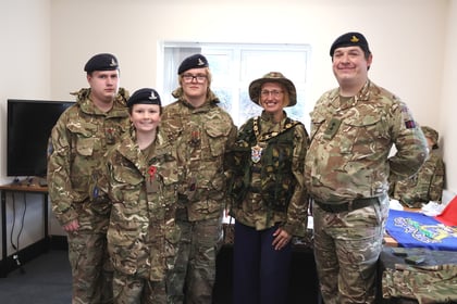 Three cadets in camouflage uniforms, a woman wearing a mayoral chain, and a soldier in camouflage pose for a group photo.