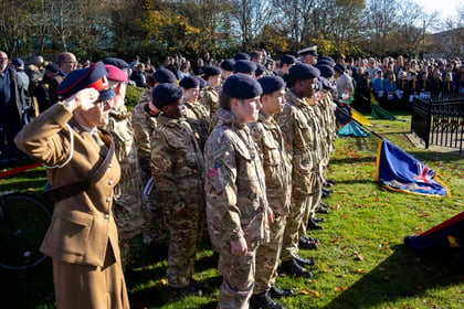 Cadet stand at attention in ranks wearing MTP uniform. Their Second Lieutenant is saluting whilst in the background banners are lowered to the ground.