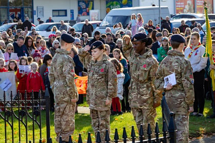 four cadet in MTP uniform being watched by a crowd of people. Two male cadets face outwards at attention whilst two female cadets face inwards saluting.