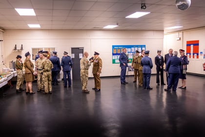 Adult instructors from both ACF and RAFAC stand in a large hall talking whilst wearing uniform both formal and working dress.