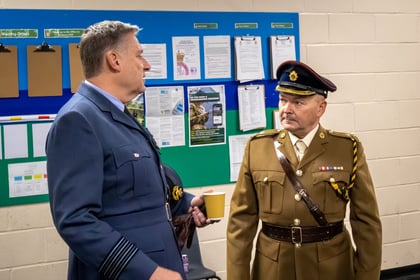An RAFAC instructor talks to a ACF instructor whilst holding a cup. Both in formal uniform.