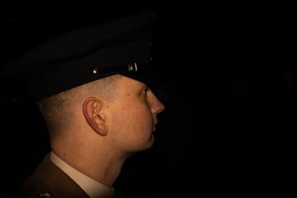 Low key picture of a Army Cadet Warrant Officer surrounded by the night.