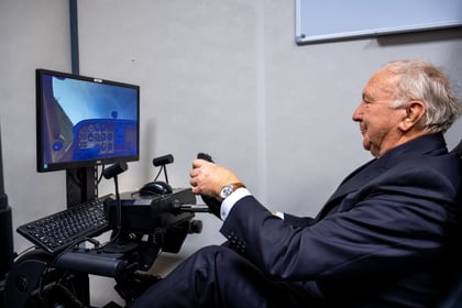 Visiting dignitary in a suit has a go on the RAFAC flight simulator.