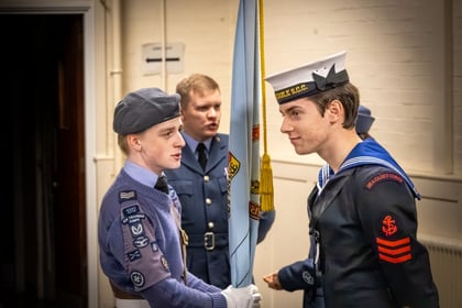 Air Cadet holding banner flag whilst talking with a Sea Cadet