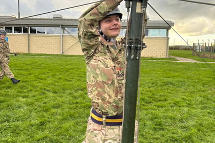 Male cadet holds onto mast in CIS training