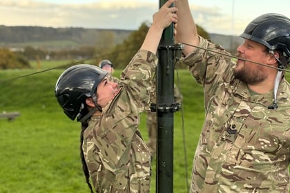 Adult volunteer shows cadet the mast for CIS