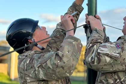Female cadet holds onto mast in CIS training
