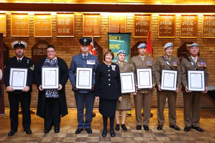 The adult volunteers lined up beside the Lord Lieutenant with their awards