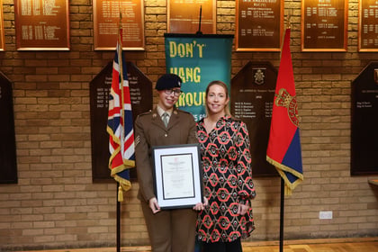 Suffolk ACF Cadet poses with her parent and her award