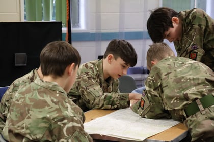 Cadets sat at a table with a map in the middle of them