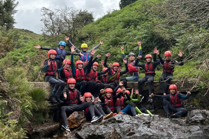 Cadets ontop of a small waterfall all waving