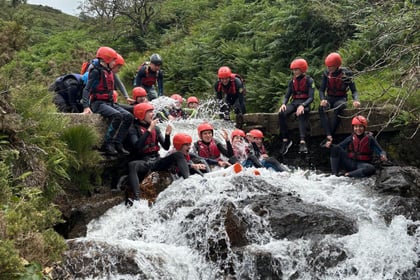 Cadets getting hit by the water on a waterfall