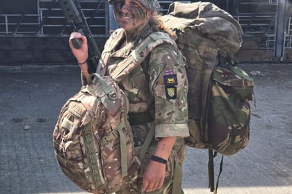 Cadet with large backpack and smaller backpack on her front