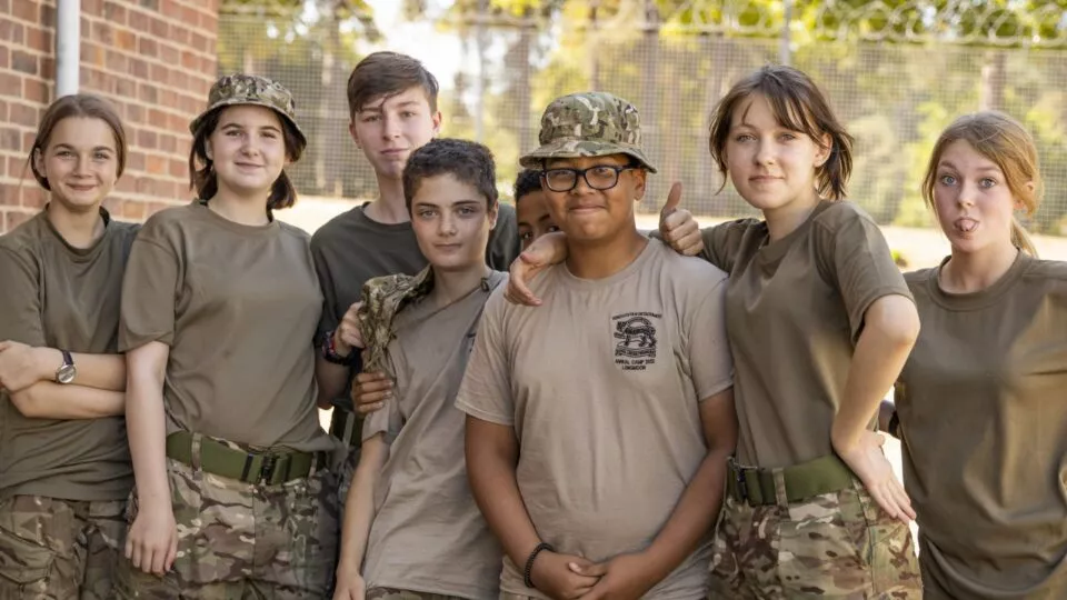 Group photo of cadets smiling at the camera while having a break at Annual camp