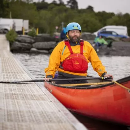 Adult instructor resting during paddle sport activities in his canoe