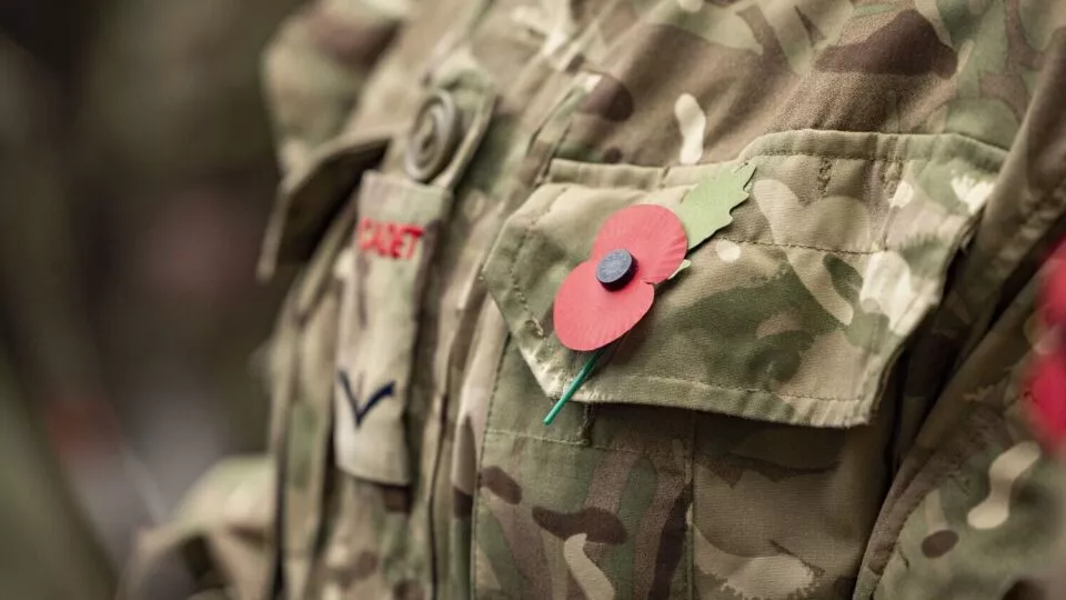 Cadet uniform with a red paper poppy for remembrance attached to the camouflage pocket.