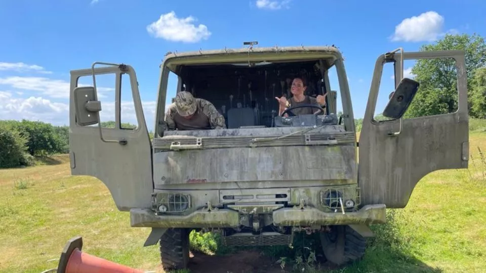 cadets sat in an old army truck with their thumbs up